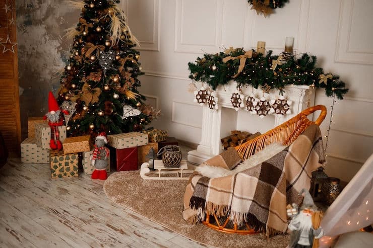 Cozy holiday living room with a decorated Christmas tree, gifts, and a festive fireplace.