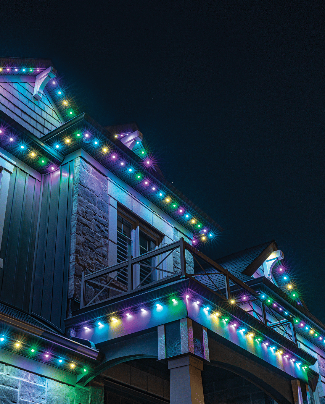 Colorful holiday lights adorning a modern home at night, enhancing the festive atmosphere.